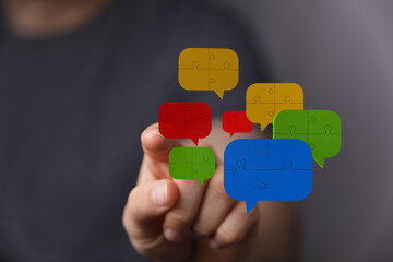 A hand points at puzzle piece speech bubbles, illustrating connection and communication for social media concepts.