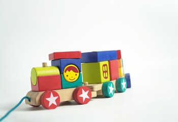 A colorful wooden toy train with blocks of different shapes and numbers, isolated against a white background. This image is perfect for concepts of childhood, learning, games, and vintage toys.

