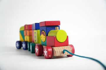 A colorful wooden toy train with blocks of different shapes and numbers, isolated against a white background. This image is perfect for concepts of childhood, learning, games, and vintage toys.

