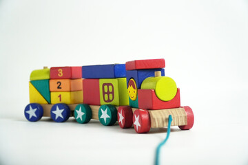 A colorful wooden toy train with blocks of different shapes and numbers, isolated against a white background. This image is perfect for concepts of childhood, learning, games, and vintage toys.

