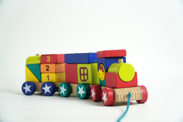 A colorful wooden toy train with blocks of different shapes and numbers, isolated against a white background. This image is perfect for concepts of childhood, learning, games, and vintage toys.

