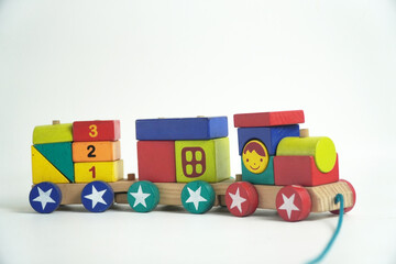 A colorful wooden toy train with blocks of different shapes and numbers, isolated against a white background. This image is perfect for concepts of childhood, learning, games, and vintage toys.

