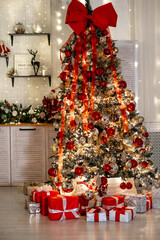 New Year's interior of the house in the kitchen with red, yellow, green decor, New Year's tree in the kitchen, New Year's festive atmosphere in the apartment, preparation for the holiday.