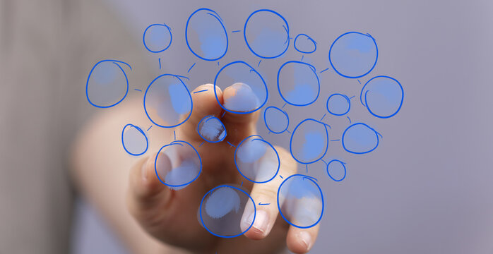 Human hand interacting with a futuristic digital interface displaying a network of interconnected blue circles. Perfect for concepts of technolo