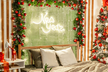 New Year's interior of the house in the bedroom with red, yellow, green decor, a bed near the Christmas tree, a New Year's festive atmosphere in the apartment