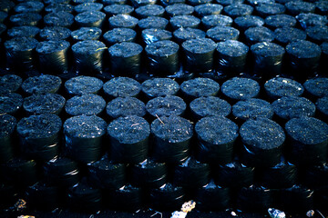 Stacked Black Cylinders on Industrial Floor in Warehouse Storage