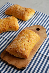Homemade Cheese Ciabatta Bread on a Wooden Board, side view.