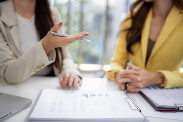 Asian businesswomen professionals discuss important financial data collaborate strategies present ideas analyze reports modern office meeting room corporate growth