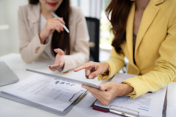 Asian adult businesswomen discuss data analysis digital tablet office project review strategy financial report collaboration partners