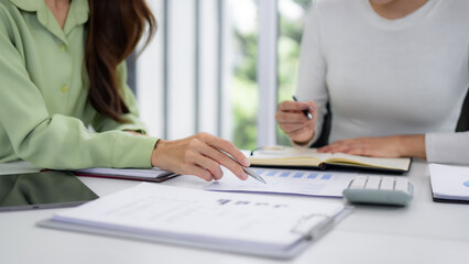 Professional business women collaborate analyze financial reports discuss growth strategy meeting room office setting