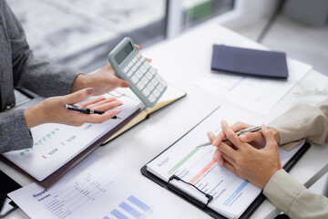 Business professionals review financial reports calculate budgets discuss investment strategy office meeting analyzing data