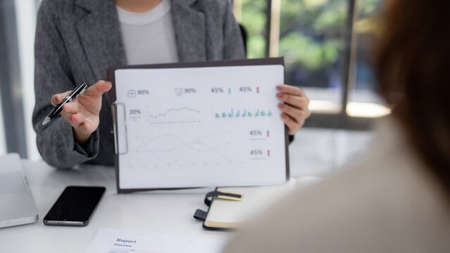 Business professional presenting data charts financial report explaining trends corporate meeting environment