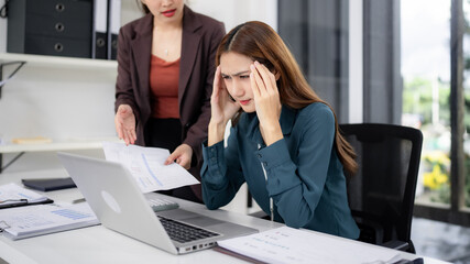 Asian businesswomen collaborate office problem solving during high pressure work deadline intense...