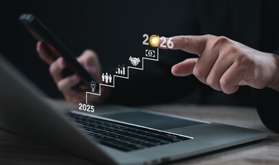 Professional pointing at digital growth steps from 2025 to 2026 with business icons, representing future planning, strategy, success, investment, progress, and corporate digital transformation.