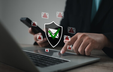 Professional using laptop and smartphone with digital shield icon, email check mark and warning alerts, representing cybersecurity, data protection, phishing prevention, and secure communication.