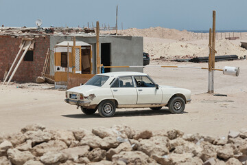 Old car in the desert, Egypt. Car under construction site, barrier, checkpoint. Shallow depth of field
