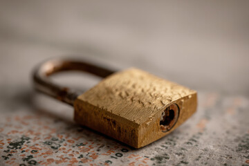 A close-up of a vintage brass padlock resting on a textured surface, showcasing intricate details and aged patina, evoking a sense of security and nostalgia