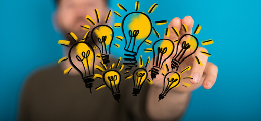 Hand touching illustrated light bulbs symbolizing inspiration and brainstorming. Concept of ideas,...