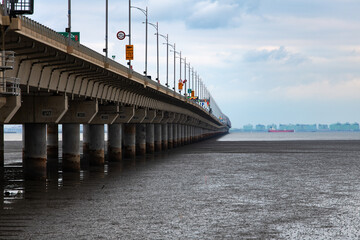 long bridge on mud flat beach and sea