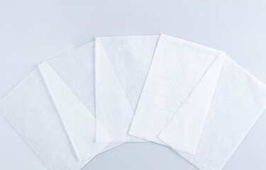Obraz premium Several white paper sheets are positioned neatly on a light grey surface, suitable for crafts, printing, or note-taking. Their clean appearance offers versatility for many uses.