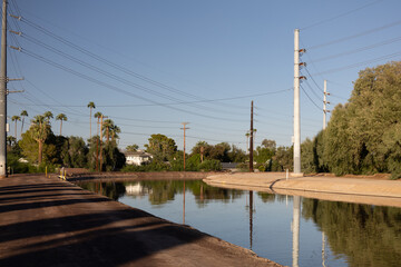 Obraz premium Arizona Canal with Palm Trees and Urban Desert Landscape in Phoenix and Scottsdale