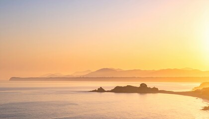 Obraz premium A serene sunset over a calm sea, with distant mountains and a rocky shoreline, creating a tranquil and picturesque coastal view.