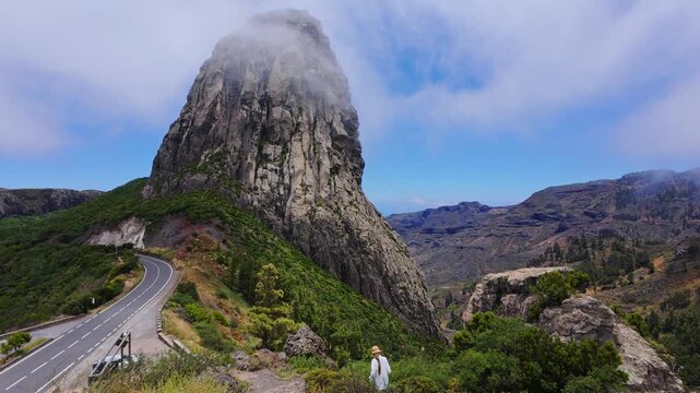 Female traveler walking along a mountain path near roque de agando