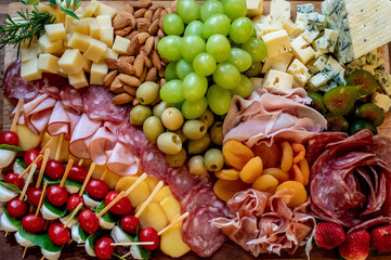 healthy food texture background, cheeses, nuts, grapes and cold cuts