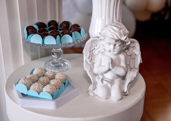 Sweets table with ceramic angel at baptism party