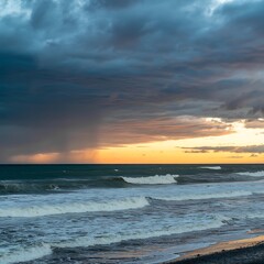 Obraz premium Dramatic Sunset Sky with Rain Falling Over Stormy Ocean Waves