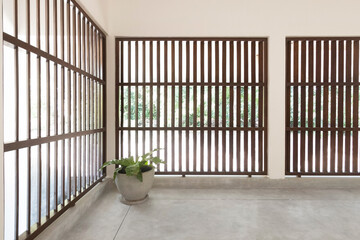 Obraz premium Modern Minimalist Room with Large Wooden Window Panels and Potted Plant