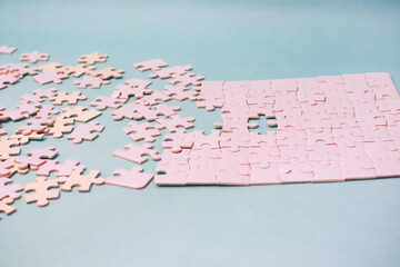 The process of solving a jigsaw puzzle, symbolizing problem-solving and cognitive skills, showcasing pink puzzle pieces on a pastel background