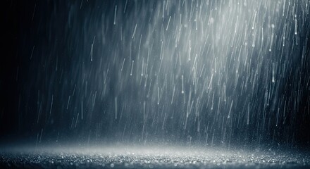 Raindrops falling on a dark surface.