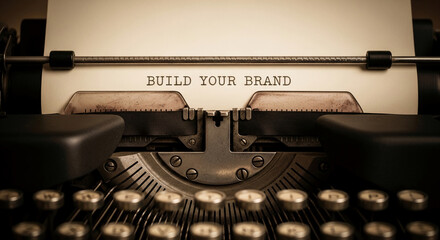 Close-up of an old typewriter with "Build Your Brand" typed on paper, representing creation, authorship, and business strategy, a concept of branding