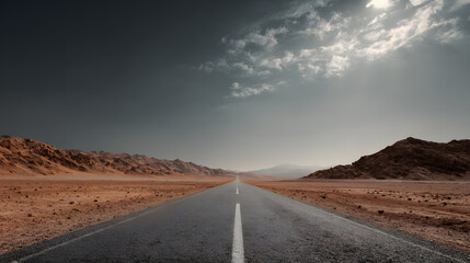 An endless road stretches through a desert landscape under a dramatic sky.