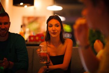 Friends enjoying a party together with drinks and a cheerful atmosphere indoors