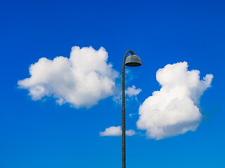 Sweden's clear blue sky with fluffy white clouds near a street lamp on a sunny day
