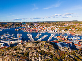 Scenic view of Skarhamn village on the west coast of Sweden featuring a bustling harbor and charming waterfront homes © Mikael