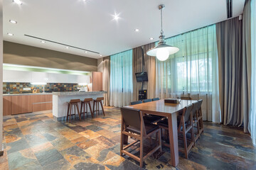 The spacious kitchen and dining room are decorated in a modern aesthetic style, with large windows...
