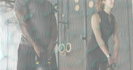 Workout partners bending squat, grasping kettlebells, performing hip drive swings for fitness - Powered by Adobe