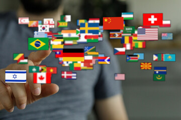 A person's hand touching flags representing various countries across the globe, symbolizing global...