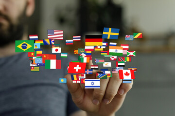 A hand holding a collection of various country flags, symbolizing global connection, unity, and diversity. Represents international relations, t