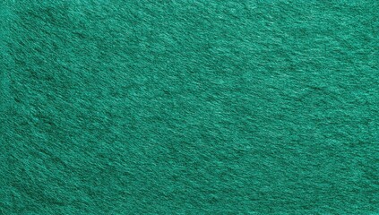Textured, close-up shot of a teal green fabric surface. Appears soft and fuzzy