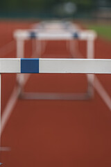 The close up of the hurdle top creates a shallow depth of field. It represents challenges obstacles and athletic competition in track and field.
