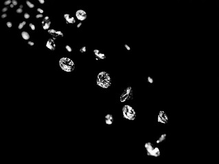 Sparkling jewels cascade against a stark black background, creating a sense of glamour