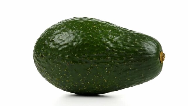 Single Ripe Avocado Isolated on White - A single, whole avocado is shown isolated against a pure white background. The avocado is dark green and appears ripe, with a slightly textured skin.