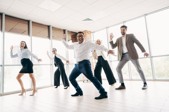 Fototapeta Team of business professionals enjoying a lively group activity together in a modern office environment