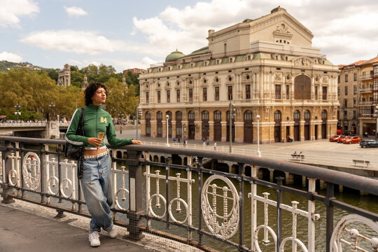 Tourist enjoying ice cream in front of victoria eugenia theater in san sebastian, spain