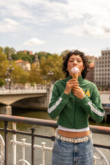 Fototapeta premium Young woman enjoying ice cream on a bridge in bilbao