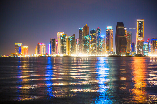 Beautiful night view of Doha city, skyscrapers of financial area and reflection in bay water. Qatar
